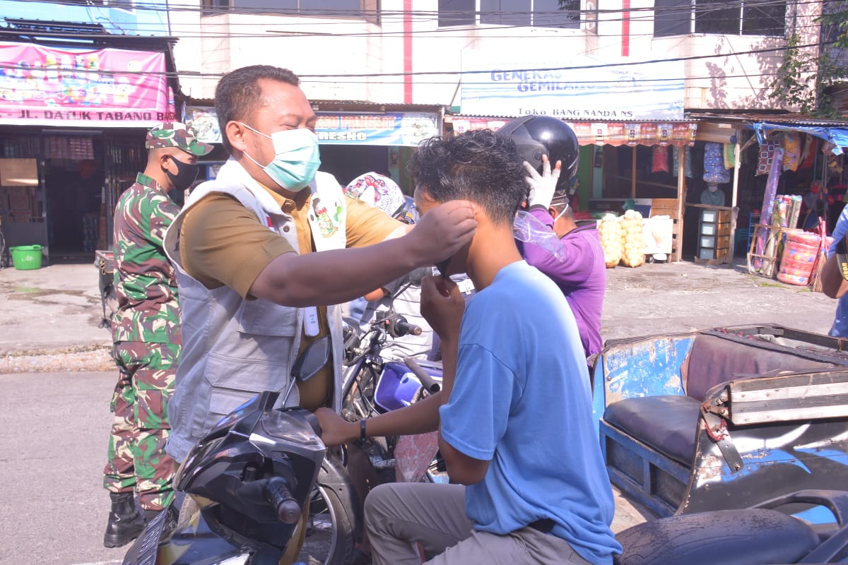 Cegah Penyebaran Covid 19 , Bupati Kampar Bagikan Masker Kepada Pedagang Dan Pengunjung Pasar Inpresi